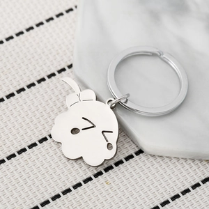Minimalist stainless steel Bocchi keychain with cute winking expression on marble background