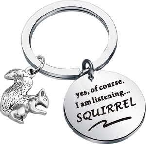 Close-up of squirrel keychain with engraved disc reading yes, of course I am listening