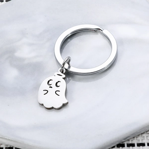 Polished stainless steel angel ghost keychain pendant on a marble textured background