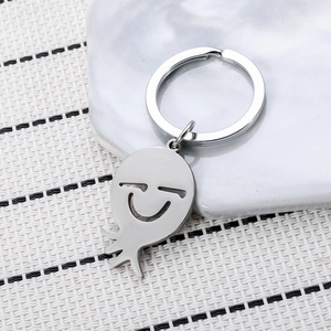Porte-clés poulpe minimaliste en acier inoxydable argenté avec sourire sur marbre