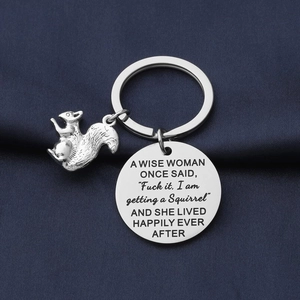 Detail of silver squirrel charm and engraved round pendant on blue fabric background