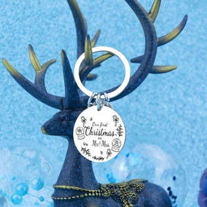 Polished silver Mr & Mrs first Christmas keychain hanging on festive blue deer ornament