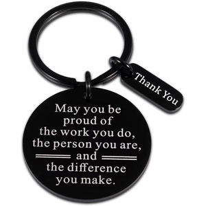 Detail of black engraved keychain with inspirational quotes on white background