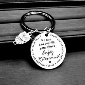 Polished stainless steel owl keychain with engraved retirement message on black background