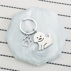 Stainless steel cartoon dog keychain with paw print pendant on marble stone
