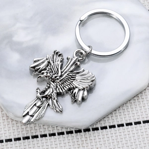 Retro eagle cross keychain in antique silver finish on a marble coaster