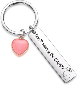 Detail of engraved stainless steel keychain with Don't Worry Be Cappy text and heart charm