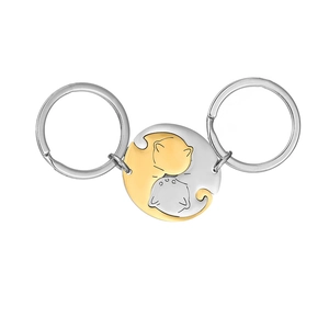 Close-up of cat puzzle keychain set in gold and silver finish with yin-yang style design