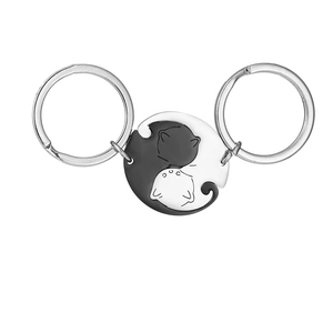 Close-up of interlocking black and white cat pendants made of durable stainless steel