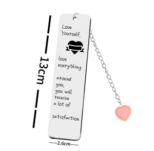 Detail showing a 13x2.6cm brushed stainless steel bookmark with engraved text and pink heart