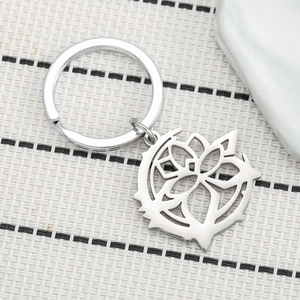 Porte-clés en acier inoxydable avec totem solaire géométrique creux sur un tapis blanc