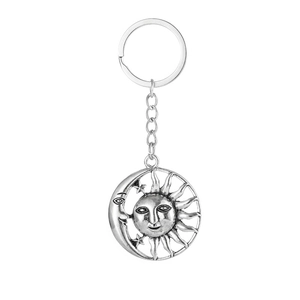 Close-up of retro bohemian sun and moon metal keychain with intricate carved details