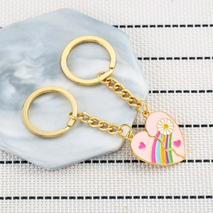 Detail of pink enamel heart rainbow keychain set with gold metal chain and daisy pattern