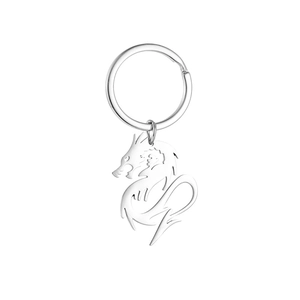 Detailed macro view of a silver dragon pendant with hollow carving on metal keychain