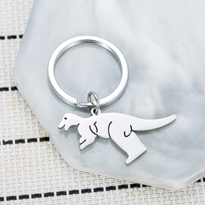 Minimalist dinosaur stainless steel keychain on a modern marble hexagon display card