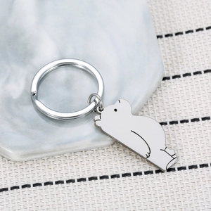 Cartoon polar bear stainless steel keychain with polished finish on marble background