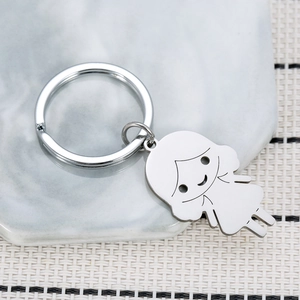 Polished stainless steel cartoon girl keychain pendant on a modern marble texture base