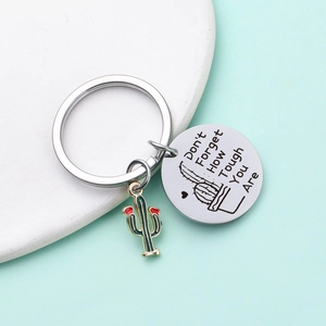 Detail of stainless steel cactus keychain with engraved motivational text and enamel charm