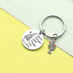 Close-up of stainless steel keychain with engraved quote and cactus enamel charm