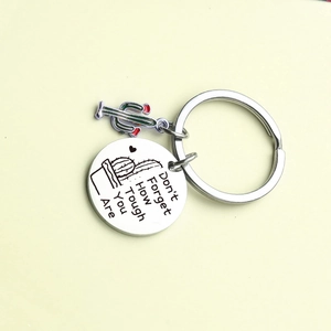 Macro detail of stainless steel keychain with cactus charm and inspirational engraving