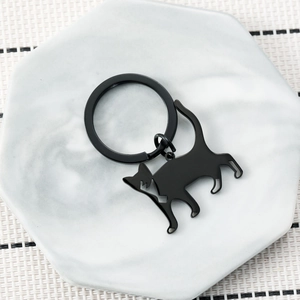 Minimalist black stainless steel cat silhouette keychain with matte finish on marble background