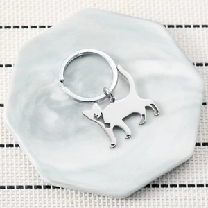 Minimalist cat silhouette stainless steel keychain on a marble plate with modern vibe