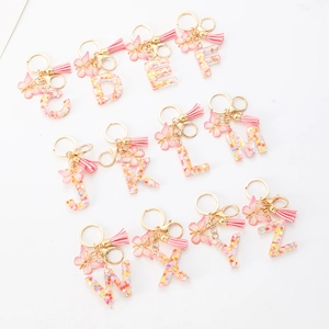 Pink glitter resin alphabet keychain with heart sequins, pink tassel and butterfly charm