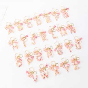 Pink resin alphabet keychain set with floral sequins, butterfly charms and tassels