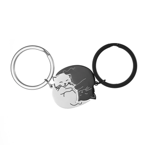 Close-up of interlocking black and white magnetic cat keychains for couples