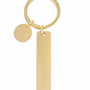Polished gold stainless steel keychain with rectangle tag and round pendant on white background