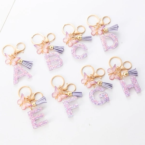Close-up of A-H purple resin alphabet keychains with butterfly and tassel charms