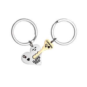 Détail de la clé dorée et du pendentif cœur argenté avec gravure I Love You élégante
