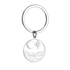 Macro detail of silver stainless steel keychain with hollow star moon and wave design