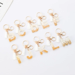 White stone resin alphabet keychain with gold foil flakes and matching tassel