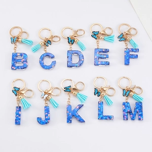Blue resin alphabet keychain with heart sequins, blue butterfly charm and gold keyring