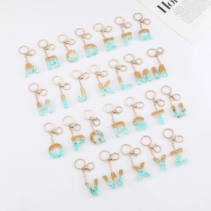 26 gold foil and green stone resin initial letter keychains set in alphabetical order