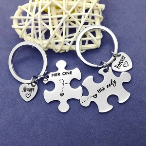 Macro detail of puzzle-shaped couple keychains with Her One and His Only engraving