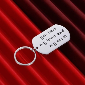 Silver stainless steel heart keychain with funny quote on a red textured background