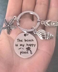 Detail of beach keychain with starfish, seashell and flip-flop charms in hand