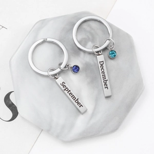 Stainless steel birthstone keychain with monthly engraved bar and colored crystal pendant