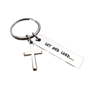 Close-up of silver stainless steel cross keychain with engraved Let God Lead text