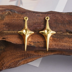 Vue détaillée de breloques étoiles à quatre branches plaquées or 18 carats sur bois