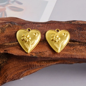 Macro dettagliata di ciondoli a cuore dorati con motivi floreali a rilievo su legno