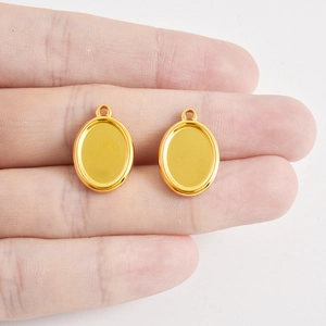 Detailopname van gouden ovale roestvrijstalen hangerbakjes voor DIY-sieraden maken