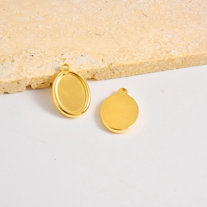 Detailopname van twee gouden ovale roestvrijstalen hangers voor DIY-sieraden maken