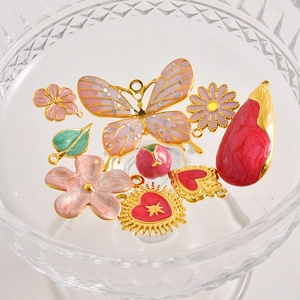 Colgantes de esmalte rosa y flores en un cuenco de cristal para joyas DIY