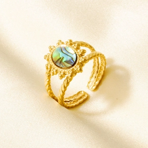 Detail van een 18k vergulde ring met abalone schelp inleg en gedraaide ringband