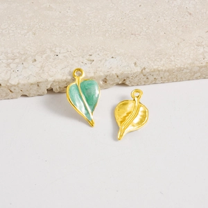 Vista macro de colgantes de hoja dorada con esmalte verde y textura de metal martillado