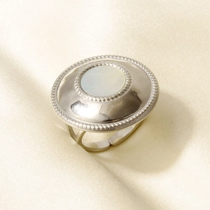 Makroaufnahme eines Vintage-Muschelrings in Silber mit Kordelrand auf Seidenstoff