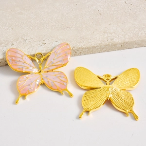 Detalle de dijes de mariposa con purpurina rosa y acabado de metal dorado fino